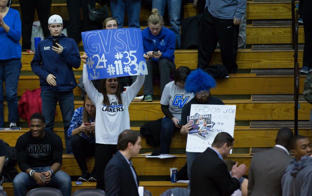 GVL / Kevin Sielaff - Taylor Shomin of Grand Valley's women's volleyball team holds a sign in support of the men's basketball team. The Lakers defeat the Cardinals of SVSU with a final score of 76-73 in Allendale.