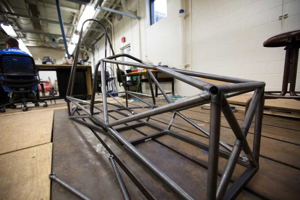 GVL / Kevin Sielaff - The nearly finished race car chassis sits behind the work bench where welding is taking place on Saturday, Feb. 27, 2016 inside the vehicle bay at Grand Valley’s John C. Kennedy Hall of Engineering.