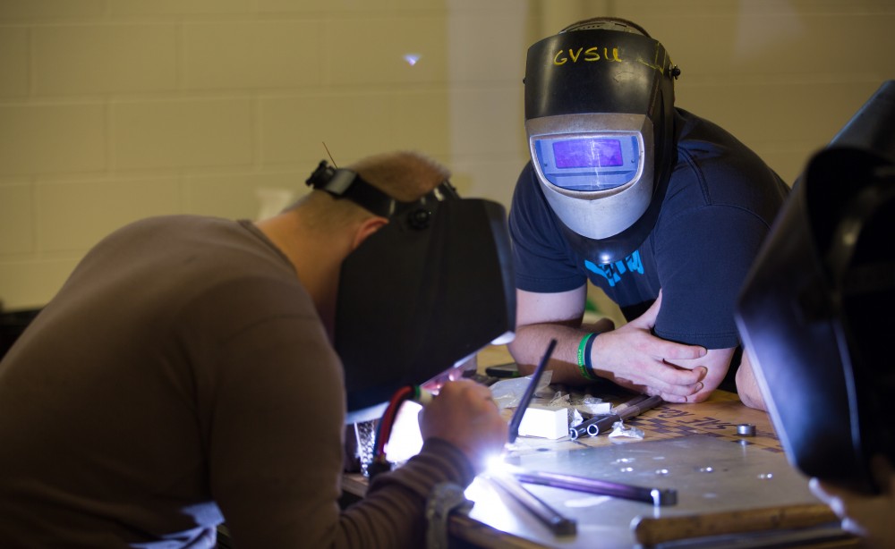 GVL / Kevin Sielaff - SAE member Chris Clark watches as welding is completed on the last few a-arms Saturday, Feb. 27, 2016 inside the vehicle bay at Grand Valley’s John C. Kennedy Hall of Engineering.