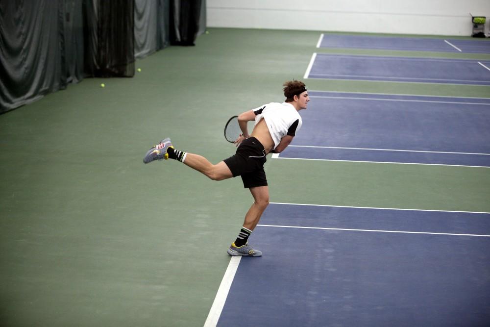 GVL / Emily Frye 
Junior Zach Phillips serves during a doubles match against Daeman College on Feb 14, 2016.