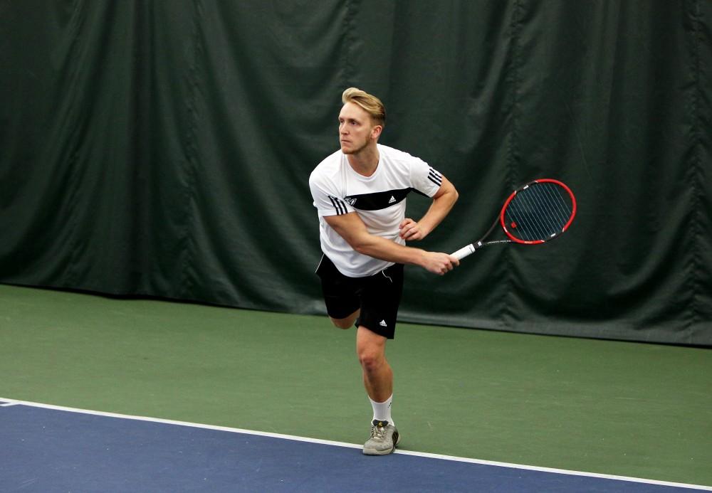 GVL / Emily Frye 
Senior Andrew Heuerman makes the serve against Davenport on Friday Feb. 19, 2016.