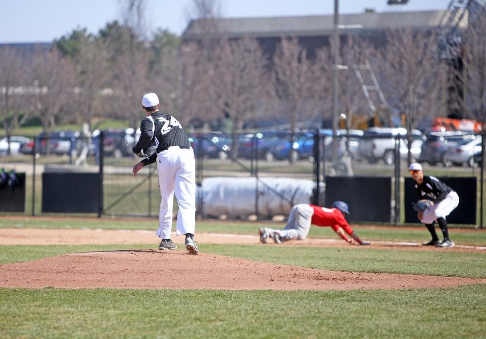 GVL / Emily Frye 
Senior Josh Griffith attempts the pick off at first base to Matt Williams against Saginaw Valley State University on Saturday Mar. 26, 2016. 