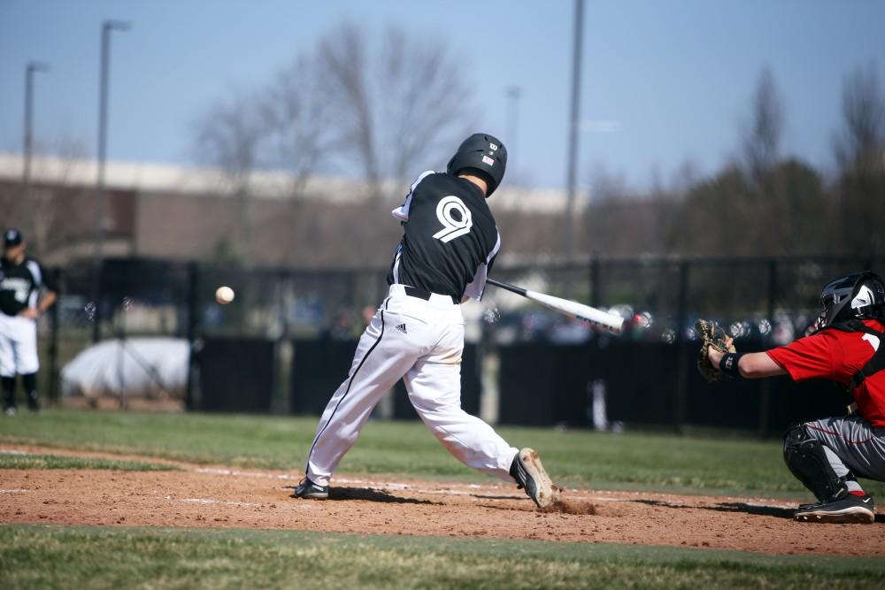 GVL / Emily Frye   
Sophomore Josh Smith makes a soild hit against Saginaw Valley State University on Saturday Mar. 26, 2016.