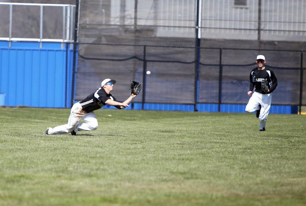 GVL / Emily Frye   
Junior Keith Browning makes a diving catch in left field against Saginaw Valley State University on Saturday Mar. 26, 2016.