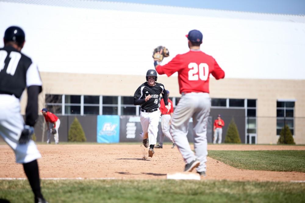 GVL / Emily Frye   
Junior Alex Young races to third base after a triple against Saginaw Valley State University on Saturday Mar. 26, 2016.