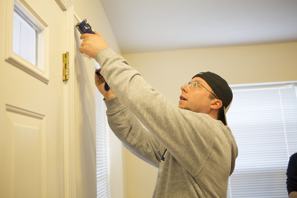 GVL / Sara Carte - Grand Valley alumni, Shaun Shira, volunteers for Kent County Habitat for Humanity in Grand Rapids on Thursday, Mar. 24, 2016.