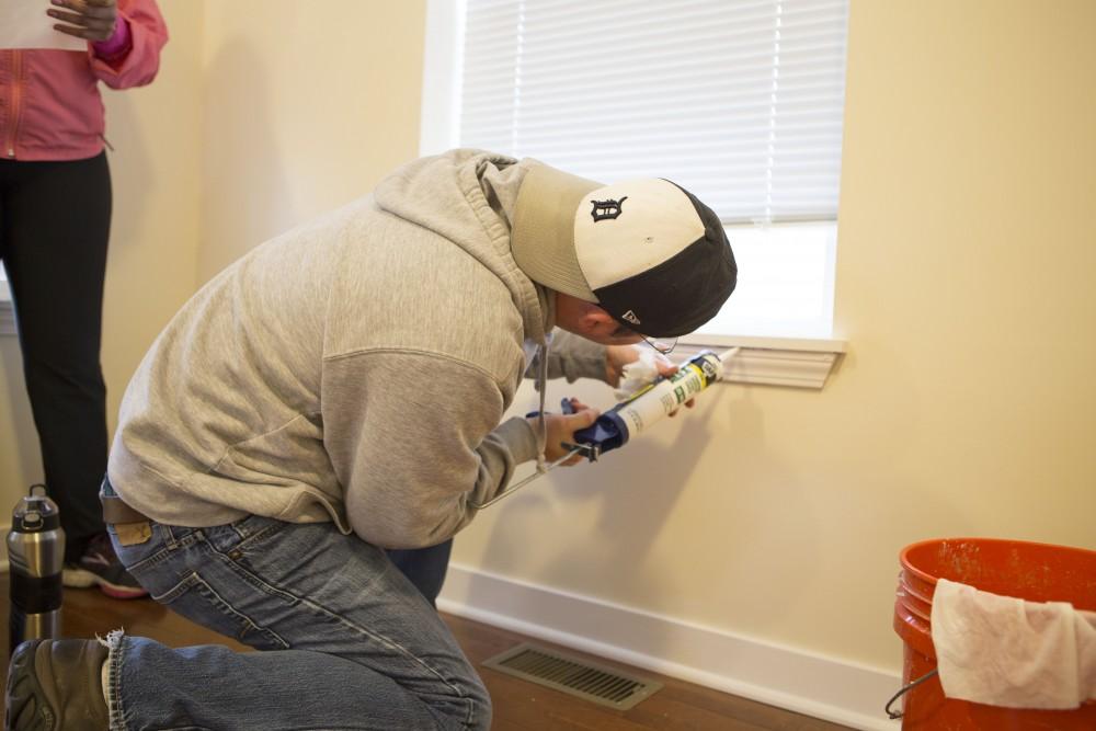 GVL / Sara Carte - Grand Valley alumni, Shaun Shira, volunteers for Kent County Habitat for Humanity in Grand Rapids on Thursday, Mar. 24, 2016.