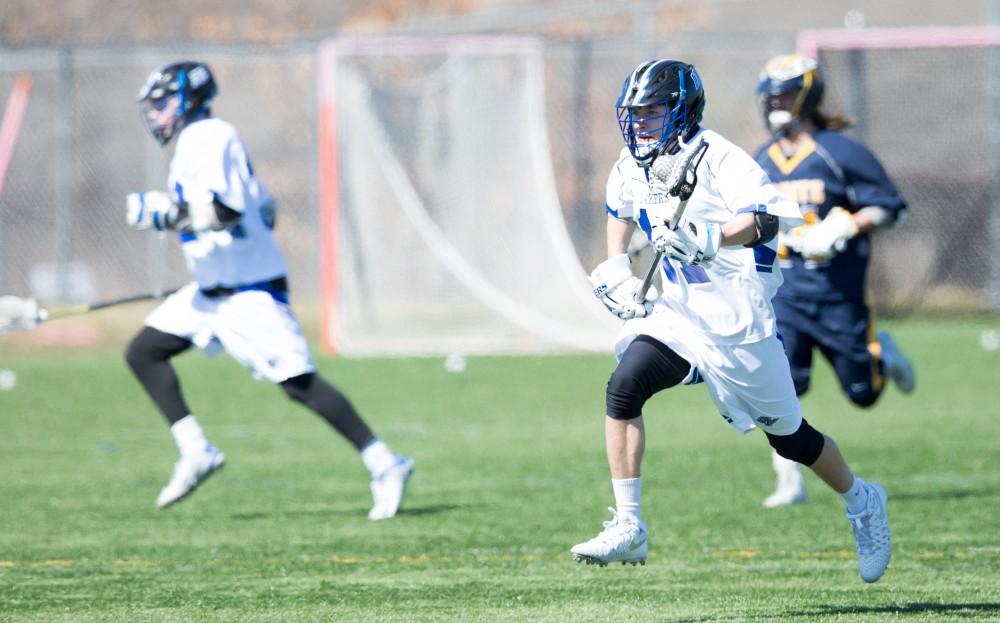 GVL / Kevin Sielaff – Peter Treppa (11) moves into Siena's zone. Grand Valley’s men’s lacrosse team squares off against Siena Heights University Sunday, March 20, 2016 in Allendale.