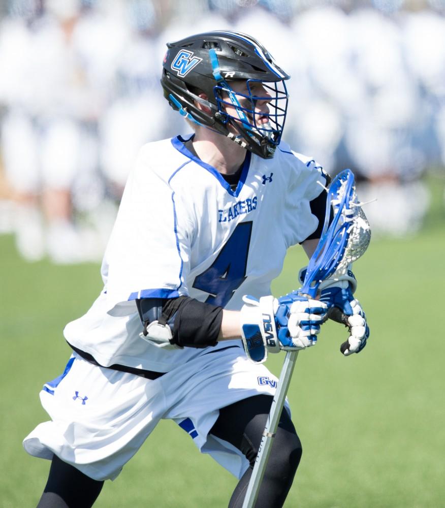 GVL / Kevin Sielaff – Erick Sundstrom (4) carries the ball up field. Grand Valley’s men’s lacrosse team squares off against Siena Heights University Sunday, March 20, 2016 in Allendale.