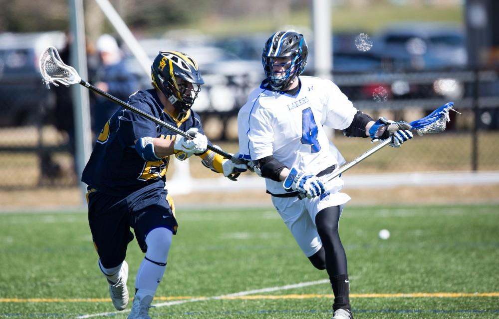 GVL / Kevin Sielaff – Erick Sundstrom (4) carries the ball up field and is defended en route. Grand Valley’s men’s lacrosse team squares off against Siena Heights University Sunday, March 20, 2016 in Allendale.