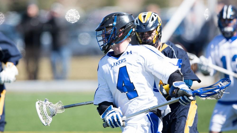 GVL / Kevin Sielaff – Erick Sundstrom (4) carries the ball up field and is defended en route. Grand Valley’s men’s lacrosse team squares off against Siena Heights University Sunday, March 20, 2016 in Allendale.