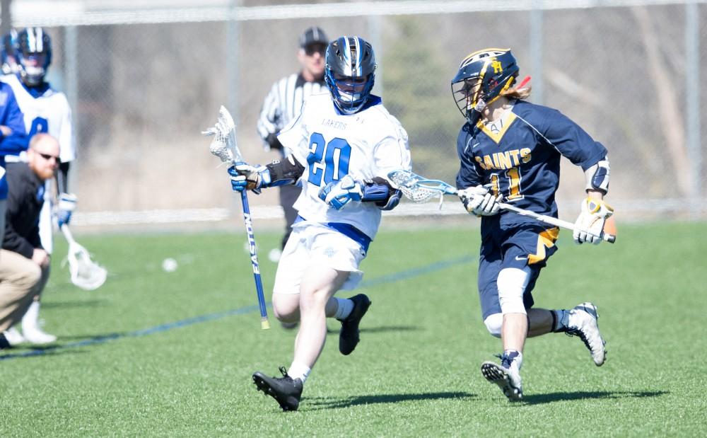 GVL / Kevin Sielaff – Zack Crawford (20) moves the ball out of Grand Valley's zone.  Grand Valley’s men’s lacrosse team squares off against Siena Heights University Sunday, March 20, 2016 in Allendale.