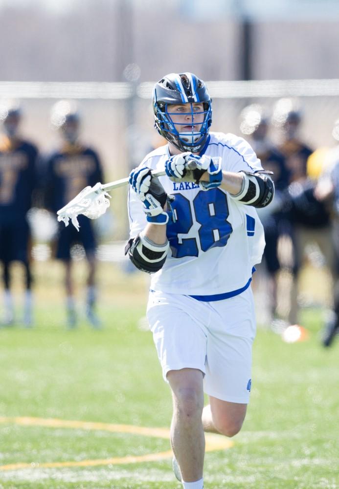 GVL / Kevin Sielaff – Seth Kuehnl (28) passes the ball. Grand Valley’s men’s lacrosse team squares off against Siena Heights University Sunday, March 20, 2016 in Allendale.