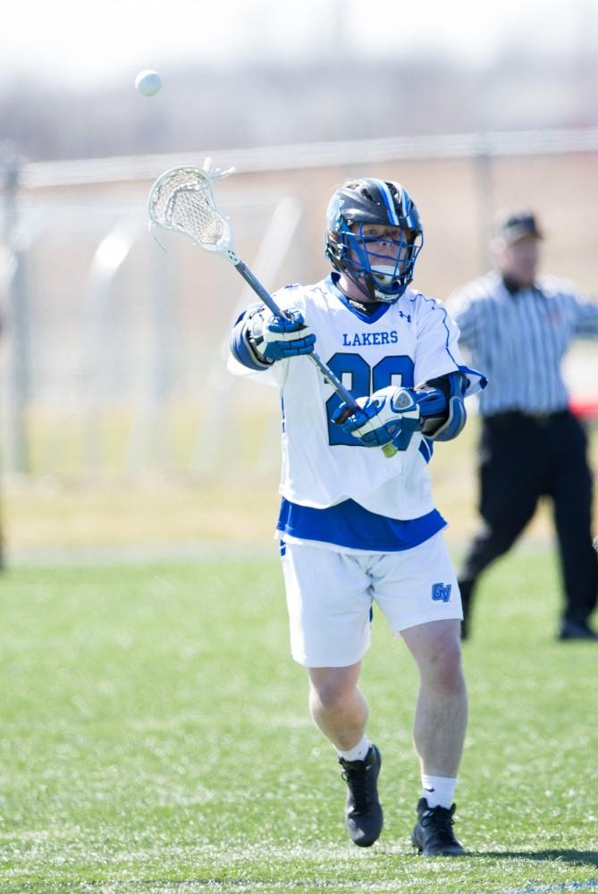 GVL / Kevin Sielaff – Zack Crawford (20) passes the ball up field. Grand Valley’s men’s lacrosse team squares off against Siena Heights University Sunday, March 20, 2016 in Allendale.