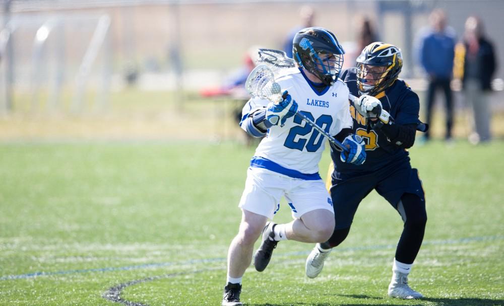 GVL / Kevin Sielaff – Zack Crawford (20) moves into Siena's zone and is defended en route. Grand Valley’s men’s lacrosse team squares off against Siena Heights University Sunday, March 20, 2016 in Allendale.