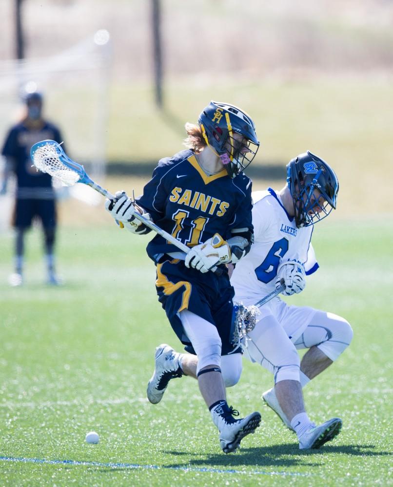 GVL / Kevin Sielaff – Brian Newton (6) runs past the ball and back-tracks to grab it. Grand Valley’s men’s lacrosse team squares off against Siena Heights University Sunday, March 20, 2016 in Allendale.