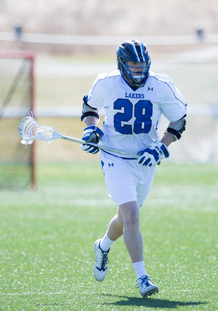 GVL / Kevin Sielaff – Seth Kuehnl (28) moves up field with the ball in hand. Grand Valley’s men’s lacrosse team squares off against Siena Heights University Sunday, March 20, 2016 in Allendale.