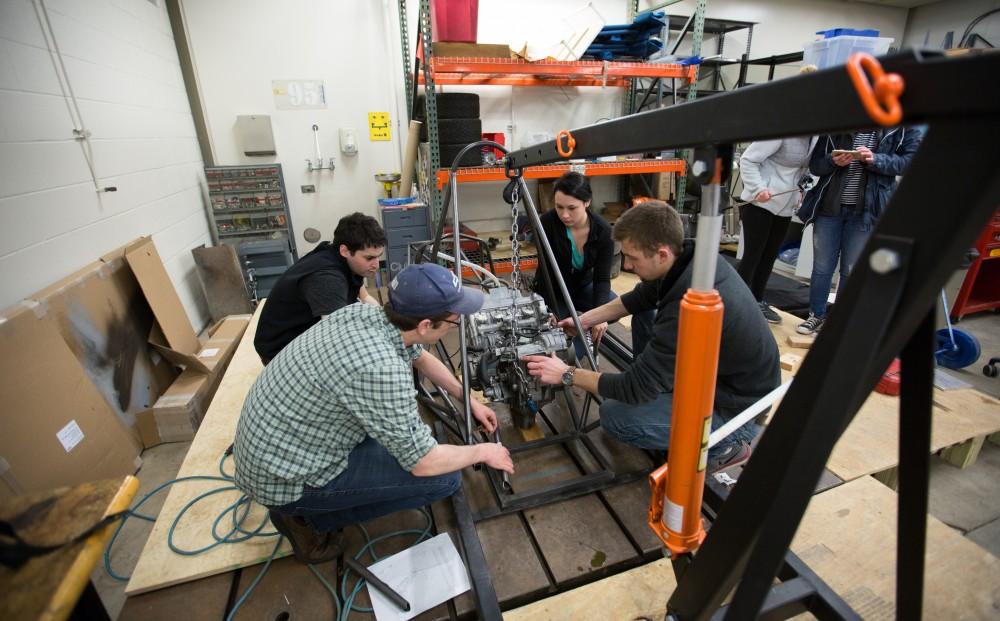 GVL / Kevin Sielaff – Members of Grand Valley’s Formula SAE Racing Team preps the engine to be mounted on the frame of the vehicle inside of the Eberhard Center’s engineering labs Thursday, March 17, 2016.