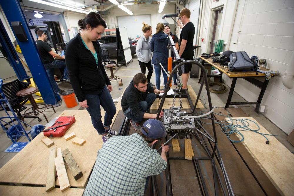 GVL / Kevin Sielaff – Members of Grand Valley’s Formula SAE Racing Team preps the engine to be mounted on the frame of the vehicle inside of the Eberhard Center’s engineering labs Thursday, March 17, 2016.