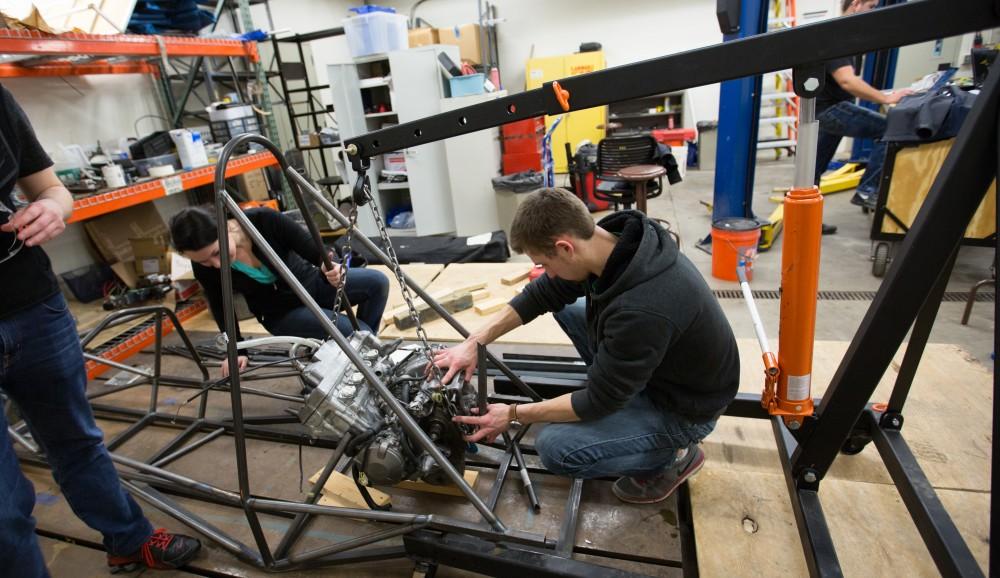 GVL / Kevin Sielaff – Members of Grand Valley’s Formula SAE Racing Team preps the engine to be mounted on the frame of the vehicle inside of the Eberhard Center’s engineering labs Thursday, March 17, 2016.