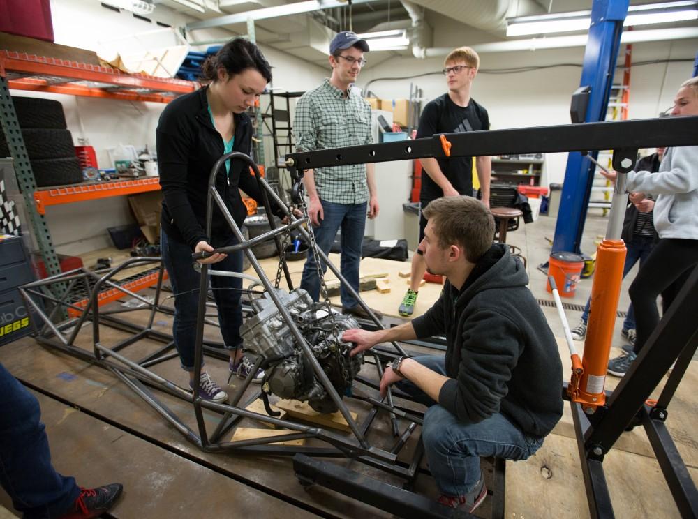 GVL / Kevin Sielaff – Members of Grand Valley’s Formula SAE Racing Team preps the engine to be mounted on the frame of the vehicle inside of the Eberhard Center’s engineering labs Thursday, March 17, 2016.