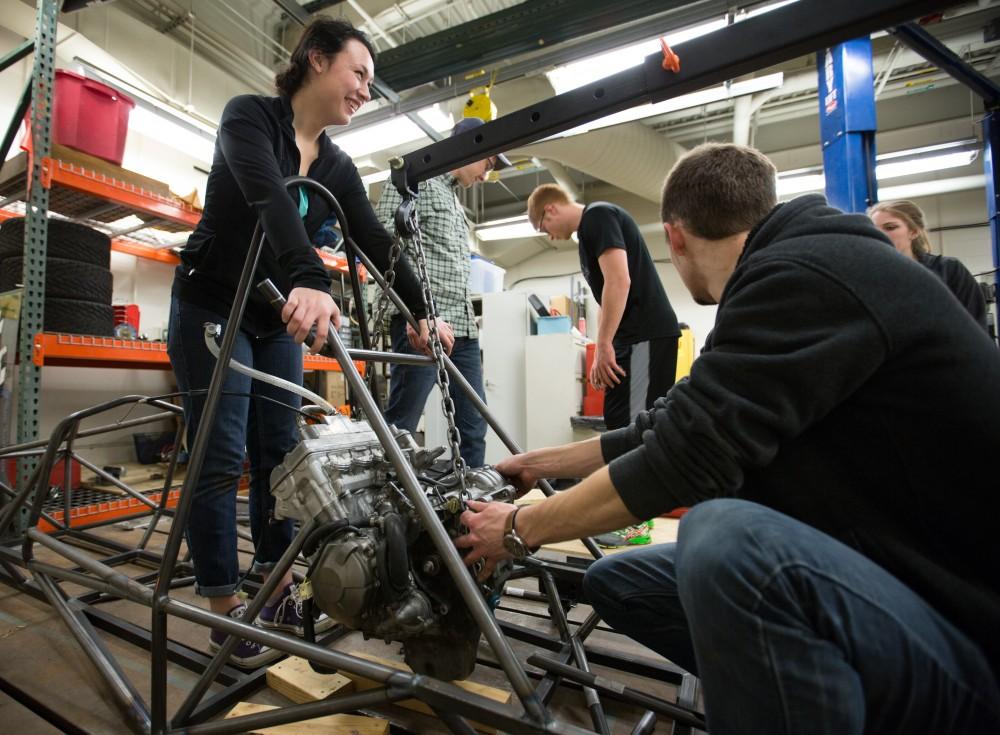 GVL / Kevin Sielaff – Members of Grand Valley’s Formula SAE Racing Team preps the engine to be mounted on the frame of the vehicle inside of the Eberhard Center’s engineering labs Thursday, March 17, 2016.