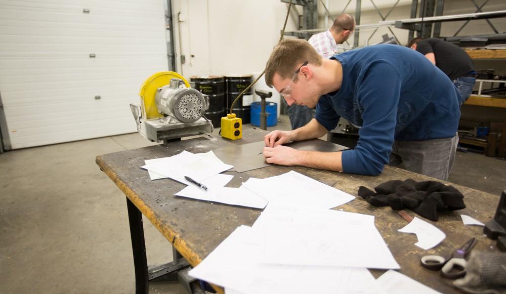 GVL / Kevin Sielaff – Members of Grand Valley’s Formula SAE Racing Team work on push-rod plugs for the vehicle’s suspension, as well as a-arm brackets inside of the Eberhard Center’s engineering labs Thursday, March 17, 2016.