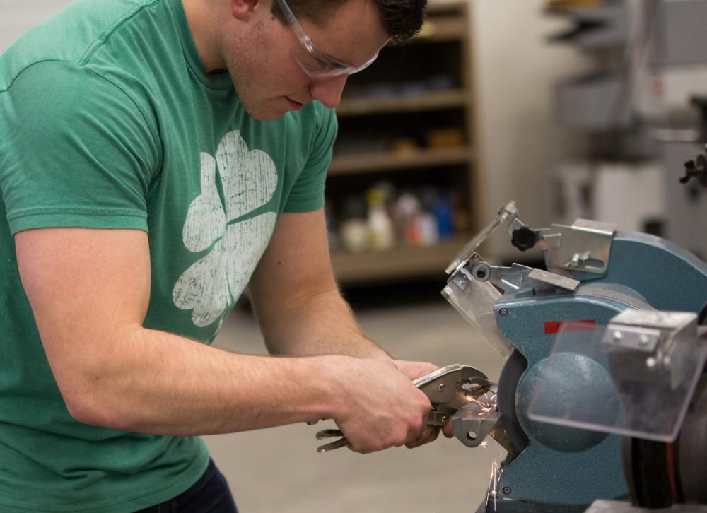 GVL / Kevin Sielaff – Members of Grand Valley’s Formula SAE Racing Team work on push-rod plugs for the vehicle’s suspension, as well as a-arm brackets inside of the Eberhard Center’s engineering labs Thursday, March 17, 2016.