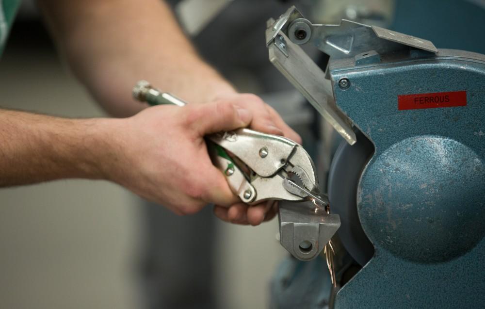 GVL / Kevin Sielaff – Members of Grand Valley’s Formula SAE Racing Team work on push-rod plugs for the vehicle’s suspension, as well as a-arm brackets inside of the Eberhard Center’s engineering labs Thursday, March 17, 2016.