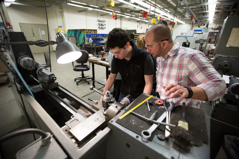 GVL / Kevin Sielaff – Members of Grand Valley’s Formula SAE Racing Team work on push-rod plugs for the vehicle’s suspension, as well as a-arm brackets inside of the Eberhard Center’s engineering labs Thursday, March 17, 2016.