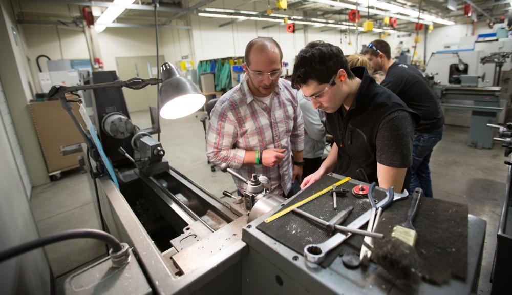 GVL / Kevin Sielaff – Members of Grand Valley’s Formula SAE Racing Team work on push-rod plugs for the vehicle’s suspension, as well as a-arm brackets inside of the Eberhard Center’s engineering labs Thursday, March 17, 2016.