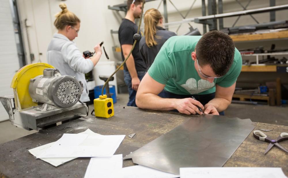 GVL / Kevin Sielaff – Members of Grand Valley’s Formula SAE Racing Team work on push-rod plugs for the vehicle’s suspension, as well as a-arm brackets inside of the Eberhard Center’s engineering labs Thursday, March 17, 2016.