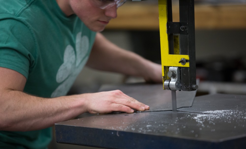 GVL / Kevin Sielaff – Members of Grand Valley’s Formula SAE Racing Team work on push-rod plugs for the vehicle’s suspension, as well as a-arm brackets inside of the Eberhard Center’s engineering labs Thursday, March 17, 2016.