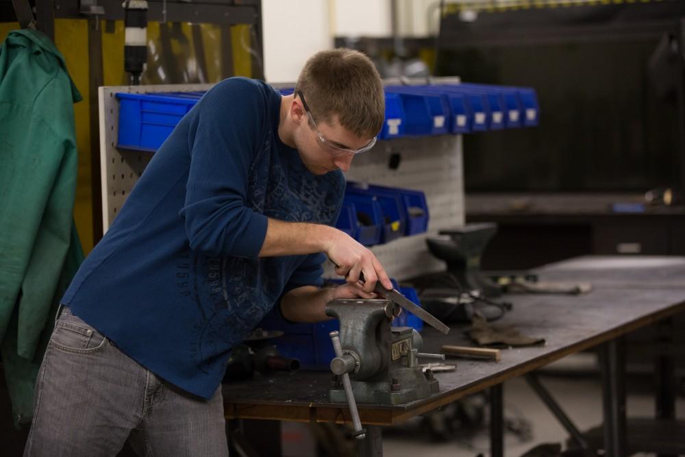 GVL / Kevin Sielaff – Members of Grand Valley’s Formula SAE Racing Team work on push-rod plugs for the vehicle’s suspension, as well as a-arm brackets inside of the Eberhard Center’s engineering labs Thursday, March 17, 2016.