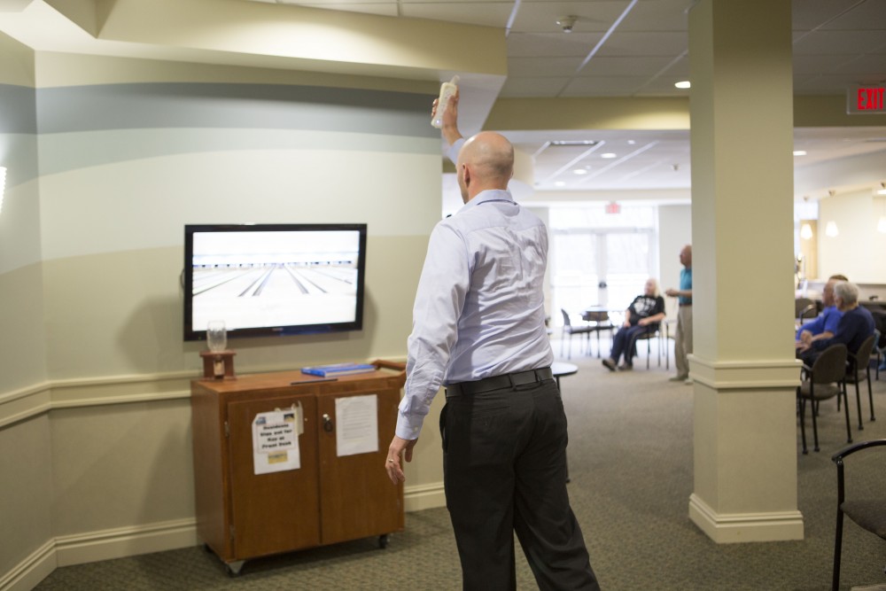 GVL / Sara Carte - Volunteer, Andrew Bopra, plays in the wii bowling tournament for Community Outreach Week at the Covenant Village of the Great Lakes on Thursday, Mar. 24, 2016.