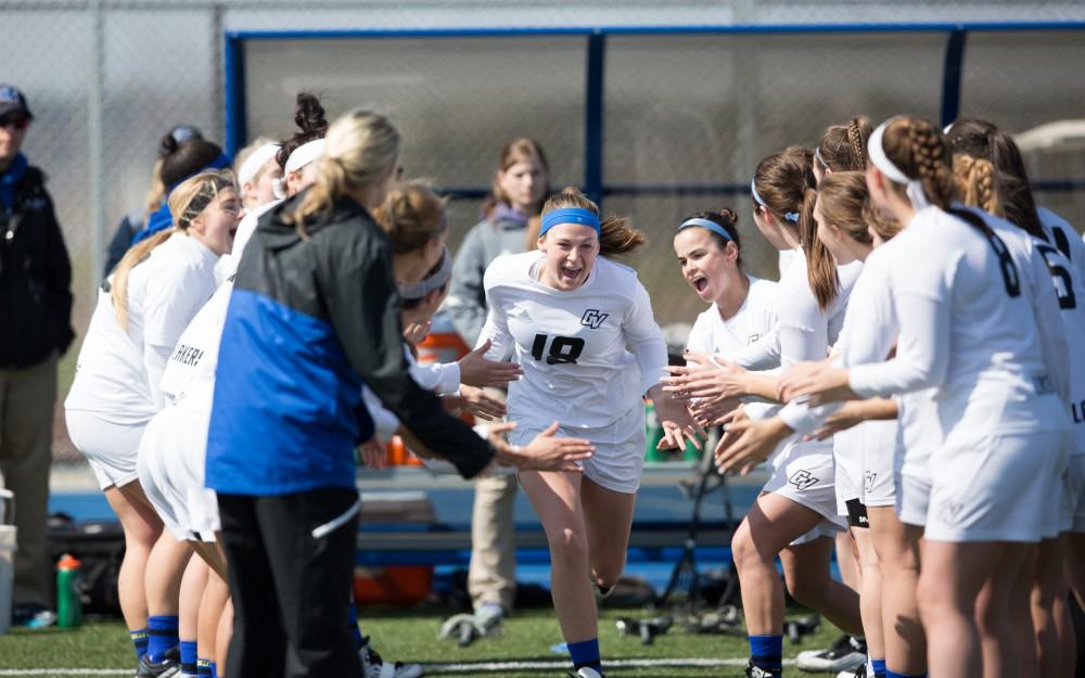 GVL / Kevin Sielaff – Meghan Datema (18) runs onto the field as the starting line-up is announced. The Lakers defeat the Greyhounds of the University of Indianapolis Saturday, March 26, 2016 with a final score of 15-4.