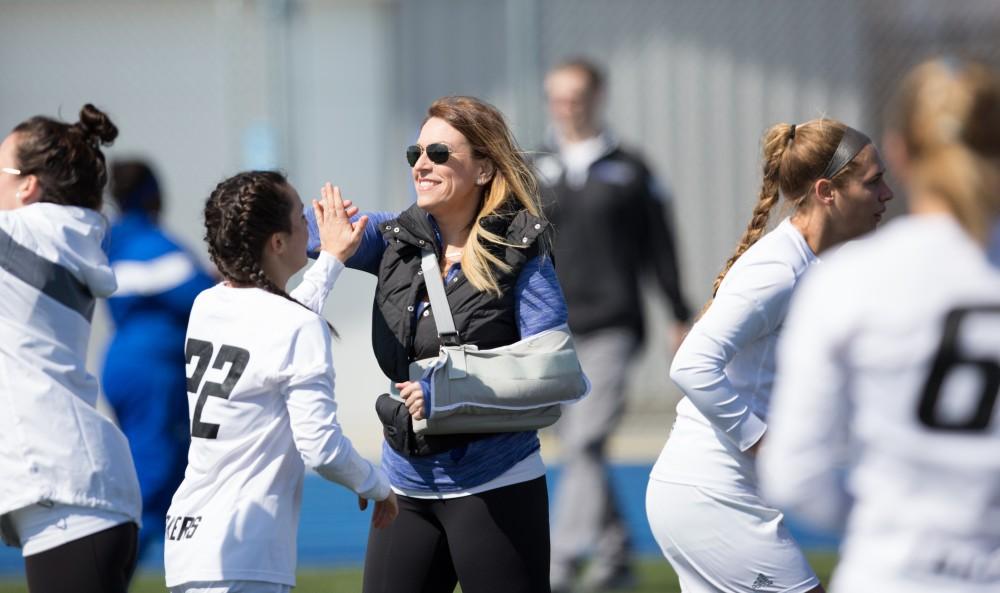 GVL / Kevin Sielaff – Head coach Alicia Groveston high-fives Kali Heller-Spencer (22) as she enters onto the field. The Lakers defeat the Greyhounds of the University of Indianapolis Saturday, March 26, 2016 with a final score of 15-4.