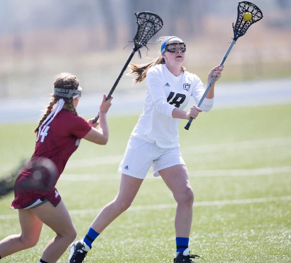 GVL / Kevin Sielaff – Meghan Datema (18) throws a pass up field. The Lakers defeat the Greyhounds of the University of Indianapolis Saturday, March 26, 2016 with a final score of 15-4.