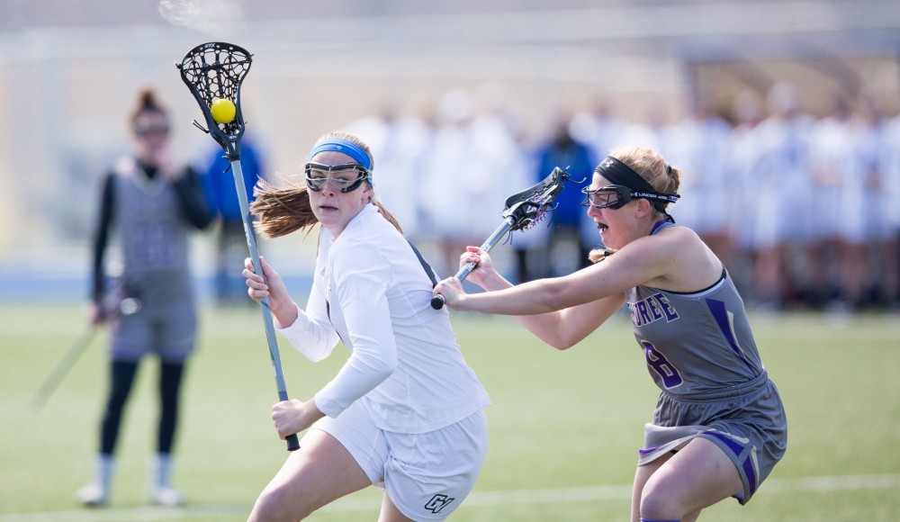 GVL / Kevin Sielaff – Meghan Datema (18) pivots around McKendree's defense and goes in for a shot on goal. The Lakers defeat the Bearcats of McKendree University with a final score of 23-11 Friday, March 25, 2016 in Allendale.