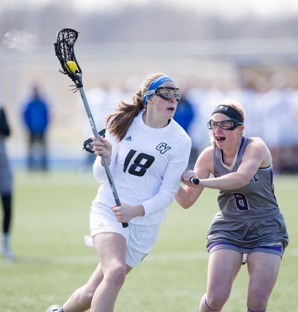 GVL / Kevin Sielaff – Meghan Datema (18) pivots around McKendree's defense and goes in for a shot on goal. The Lakers defeat the Bearcats of McKendree University with a final score of 23-11 Friday, March 25, 2016 in Allendale.