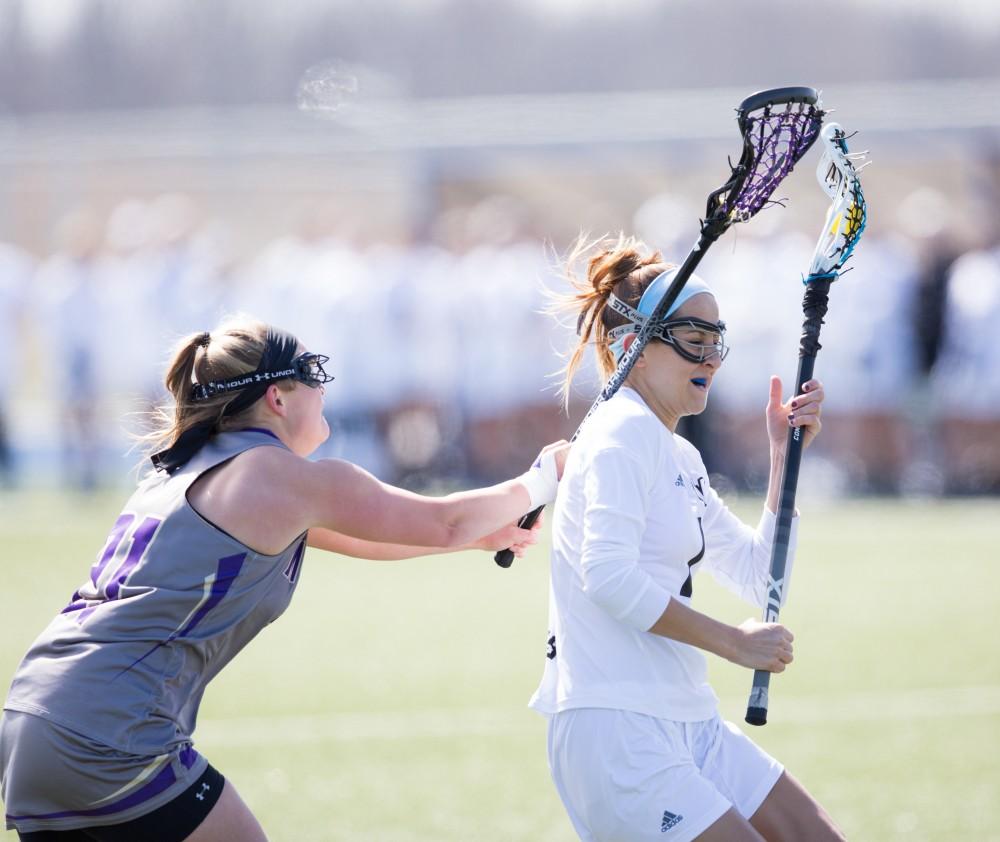 GVL / Kevin Sielaff – Ryan Skomial (1), pestered by McKendree's defense, moves in for a shot on goal. The Lakers defeat the Bearcats of McKendree University with a final score of 23-11 Friday, March 25, 2016 in Allendale.