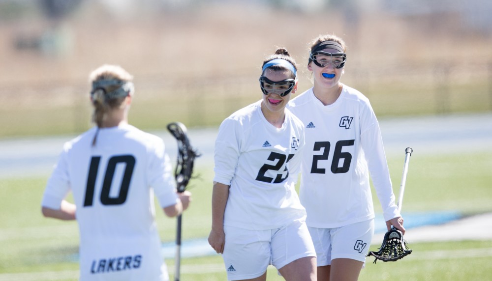 GVL / Kevin Sielaff – Katie Tomlinson (26) and Carolyn Kraus (23) celebrate a goal. The Lakers defeat the Bearcats of McKendree University with a final score of 23-11 Friday, March 25, 2016 in Allendale.