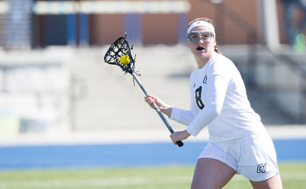 GVL / Kevin Sielaff – Livvy Mickevicius (8) throws a pass behind McKendree's net. The Lakers defeat the Bearcats of McKendree University with a final score of 23-11 Friday, March 25, 2016 in Allendale.