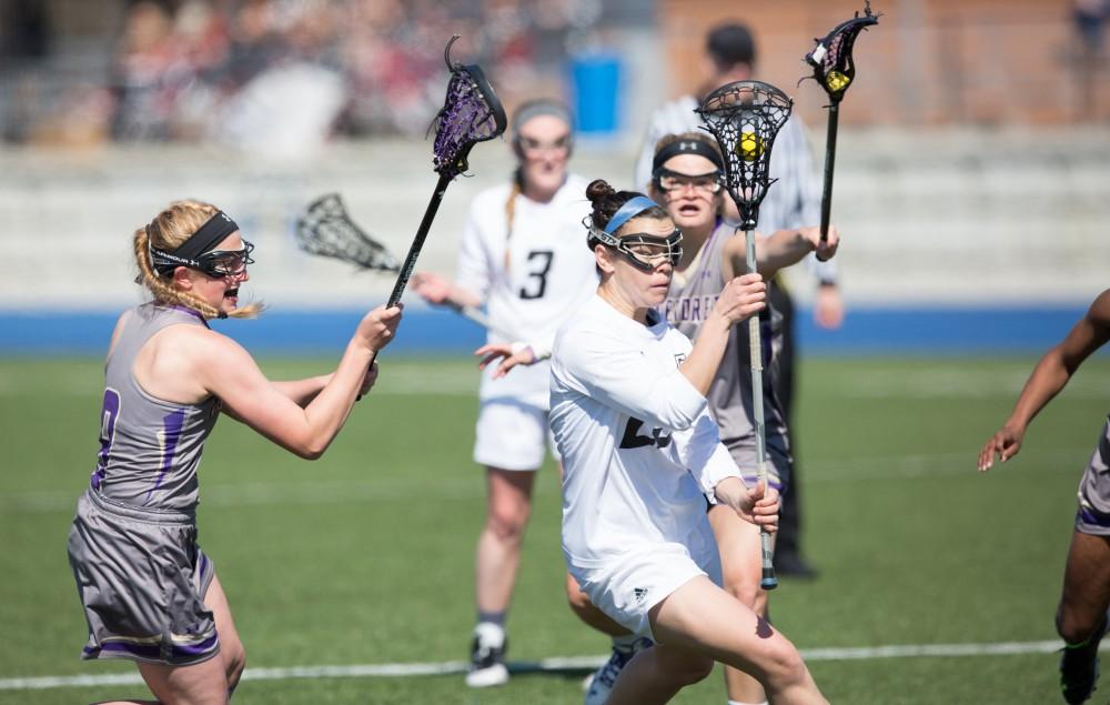 GVL / Kevin Sielaff – Carolyn Kraus (23) drives in on McKendree's net. The Lakers defeat the Bearcats of McKendree University with a final score of 23-11 Friday, March 25, 2016 in Allendale.