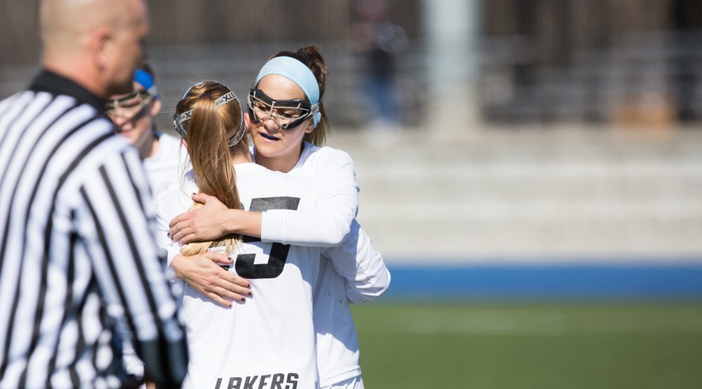 GVL / Kevin Sielaff – Ryan Skomial (1) and Carlyn Shisler (25) embrace after a goal. The Lakers defeat the Bearcats of McKendree University with a final score of 23-11 Friday, March 25, 2016 in Allendale.