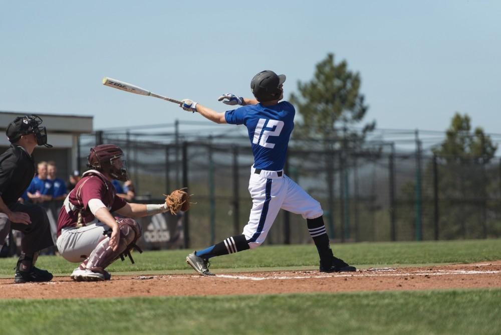 GVL / Luke Holmes - Alex Young (12) watches after hitting the ball. Grand Valley Men’s Baseball lost to Walsh college 3-4 in the first game but won 15-8 in the second game.