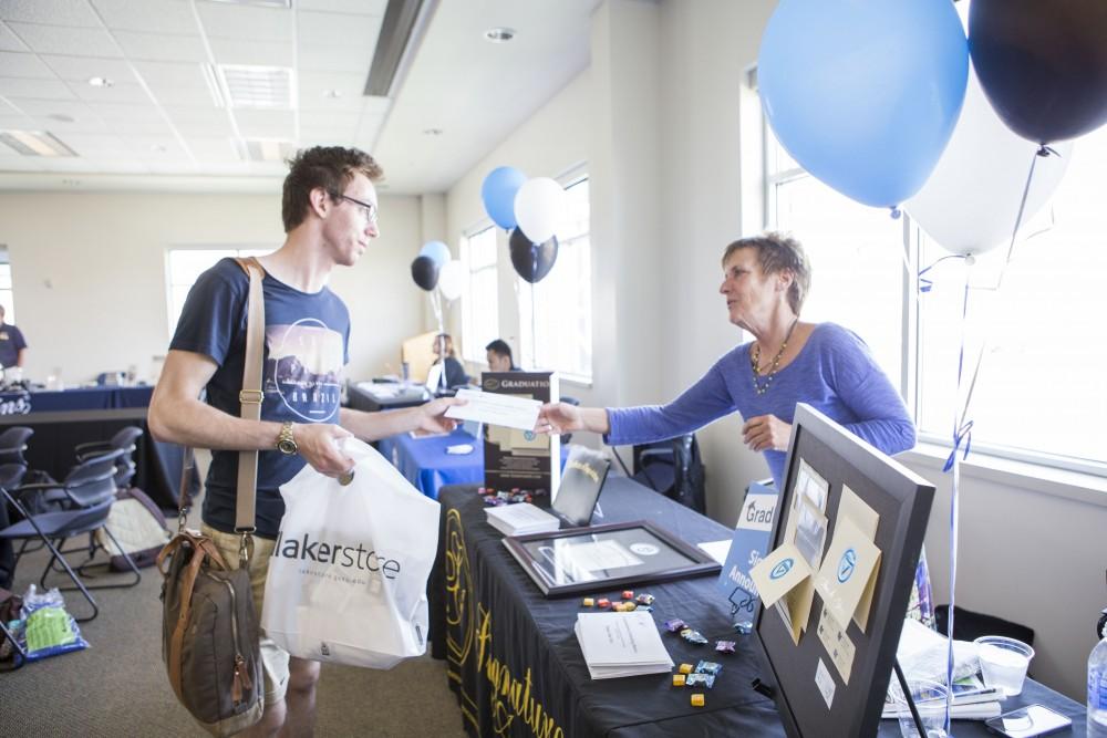 GVL / Sara Carte - Senior, Steven Richardson, picks up his signature announcements at GradFest in the Kirkhof Center on Monday, Apr. 18, 2016.