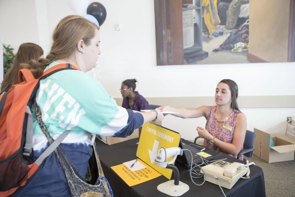 GVL / Sara Carte - Senior, Kelsey Bockelman, picks up her graduation itinerary at GradFest in the Kirkhof Center on Monday, Apr. 18, 2016.