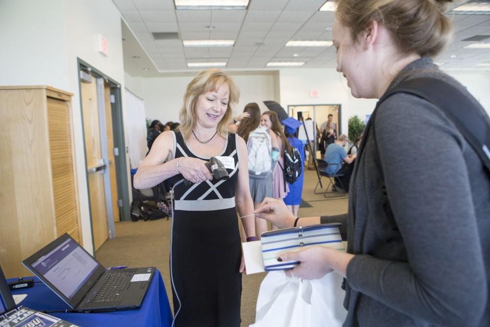 GVL / Sara Carte - GradFest helper, Robin, scans senior’s student ID’s for them to win free prizes at GradFest in the Kirkhof Center on Monday, Apr. 18, 2016.