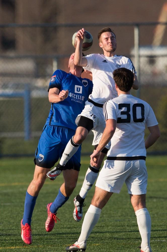 GVL / Kevin Sielaff - Garrett cooperrider (14) heads the ball in Grand Valley's zone. Grand Valley's men's club soccer team falls to GRFC with a final score of 2-0 on Friday, April 15, 2016.